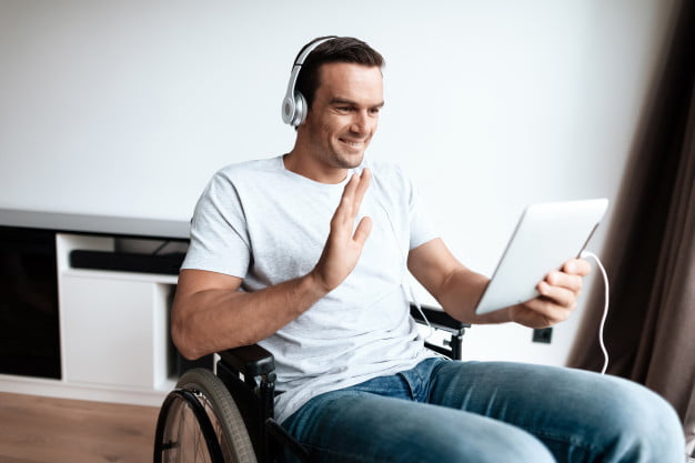 disabled-man-headphones-communicate-via-tablet