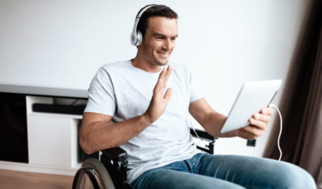 disabled-man-headphones-communicate-via-tablet